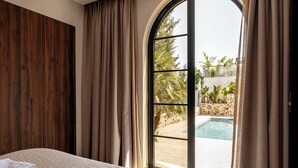 Un dormitorio con un ventanal grande, una cama y vistas a una piscina al aire libre.