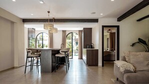 Una cocina moderna con barra, ventanas amplias y un rincón de estar acogedor.