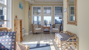 A sunlit room with wicker furniture, large windows, and a view of the street. - Walk to Main St: Condo w/ Pool Access in Crisfield (Crisfield)