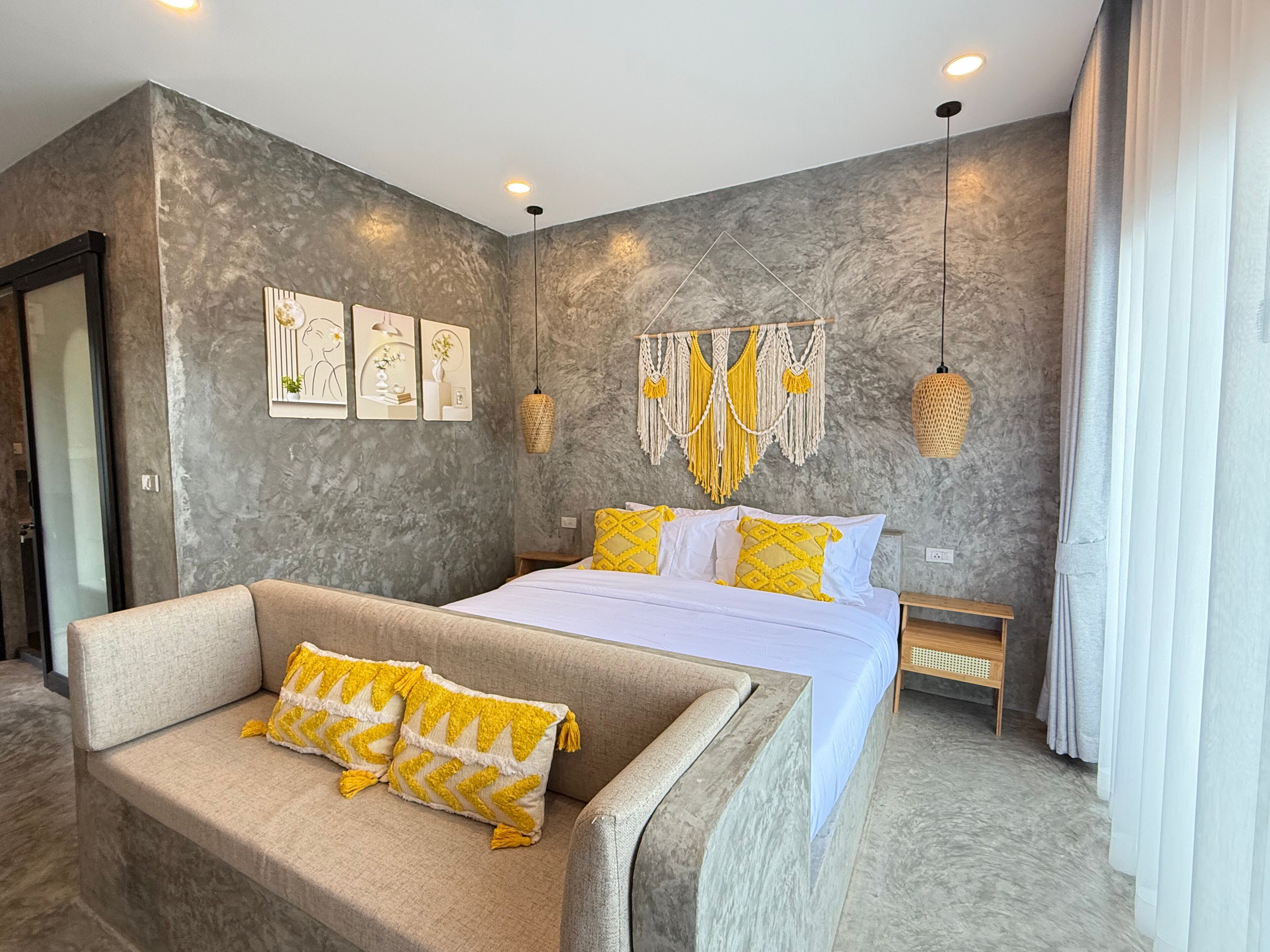 A modern bedroom with a large bed, a sofa, and a small table.