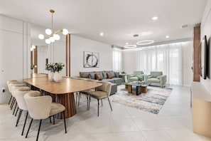 Una sala de estar moderna con comedor, un conjunto de sofás y una mesa de centro.