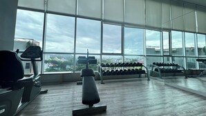 A gym with large windows, treadmills, and dumbbells. - Baan Kiang Fah Hua Hin By Thita (Hua Hin)