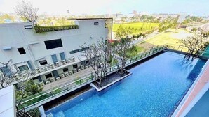 A rooftop pool with a view of a cityscape, surrounded by greenery and modern buildings. - Baan Kiang Fah Hua Hin By Thita (Hua Hin)