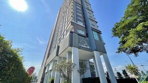 A tall, modern building with a unique architectural design, featuring a series of balconies and large windows. - Baan Kiang Fah Hua Hin By Thita (Hua Hin)