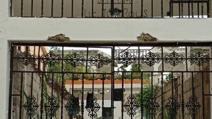 Una entrada protegida por un portón metálico y detalles de hierro decorativo.