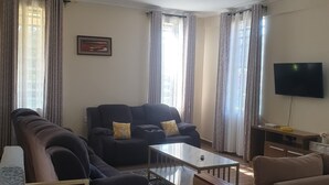 Un salon comprenant un canapé, une table basse et un téléviseur.