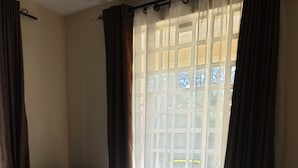 Une chambre d’hôtel avec un grand lit, un canapé et une fenêtre avec des rideaux.