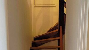 A wooden staircase with a handrail, leading to a door at the top. - Duplex in charming neighborhood overlooking chateau, close to downtown and all amenities (Clisson)