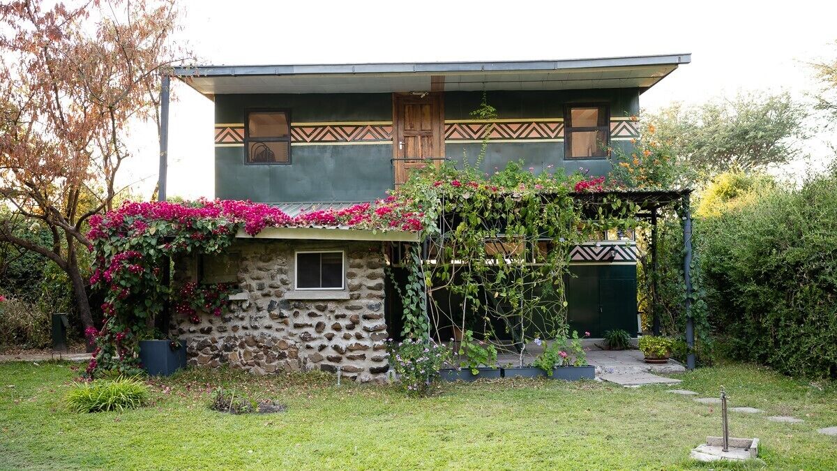 A two-story house with a stone foundation and a wooden upper level.