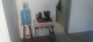 Kitchenette area with a water dispenser, coffee maker, and tea set.