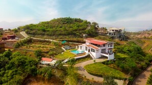A hillside property with a large house, a swimming pool, and a view of a mountain. - Villa 108 Amarja's Sierra Vista (Mawal)