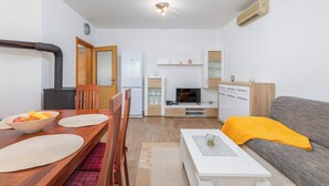 Un espace de vie compact comprenant un coin repas, une kitchenette et un coin salon.