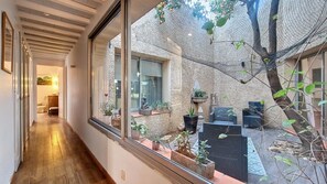 A modern interior with a long hallway leading to a living area with a view of a courtyard. - Architect-designed house for rent in Canet-en-Roussillon, 10-minute walk from the beach (Canet-en-Roussillon)
