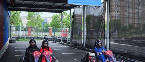 A go-kart track with three go-karts and two riders.