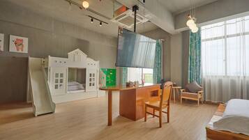 A child-friendly room with a playhouse, a desk, and a bed.