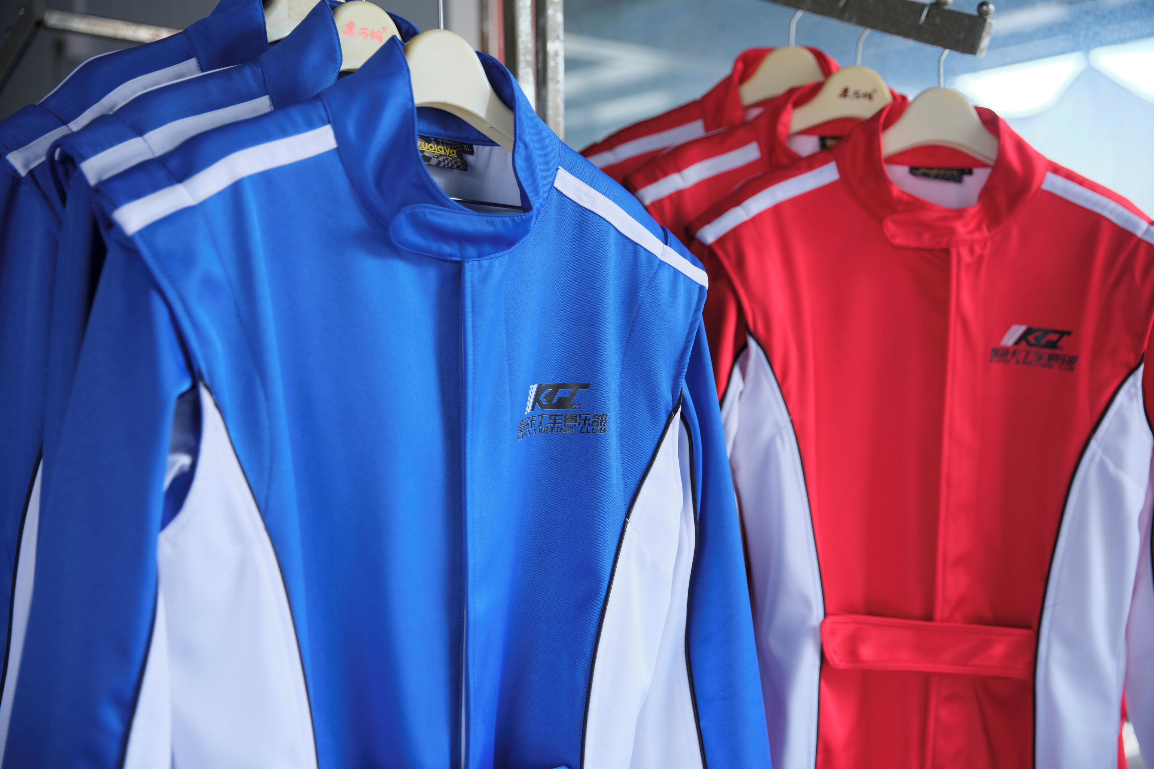Una percha con chaquetas deportivas en colores azul y rojo.
