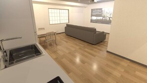 Una cocina moderna con un lavamanos integrado y una zona de comedor con una mesa y sillas de madera.