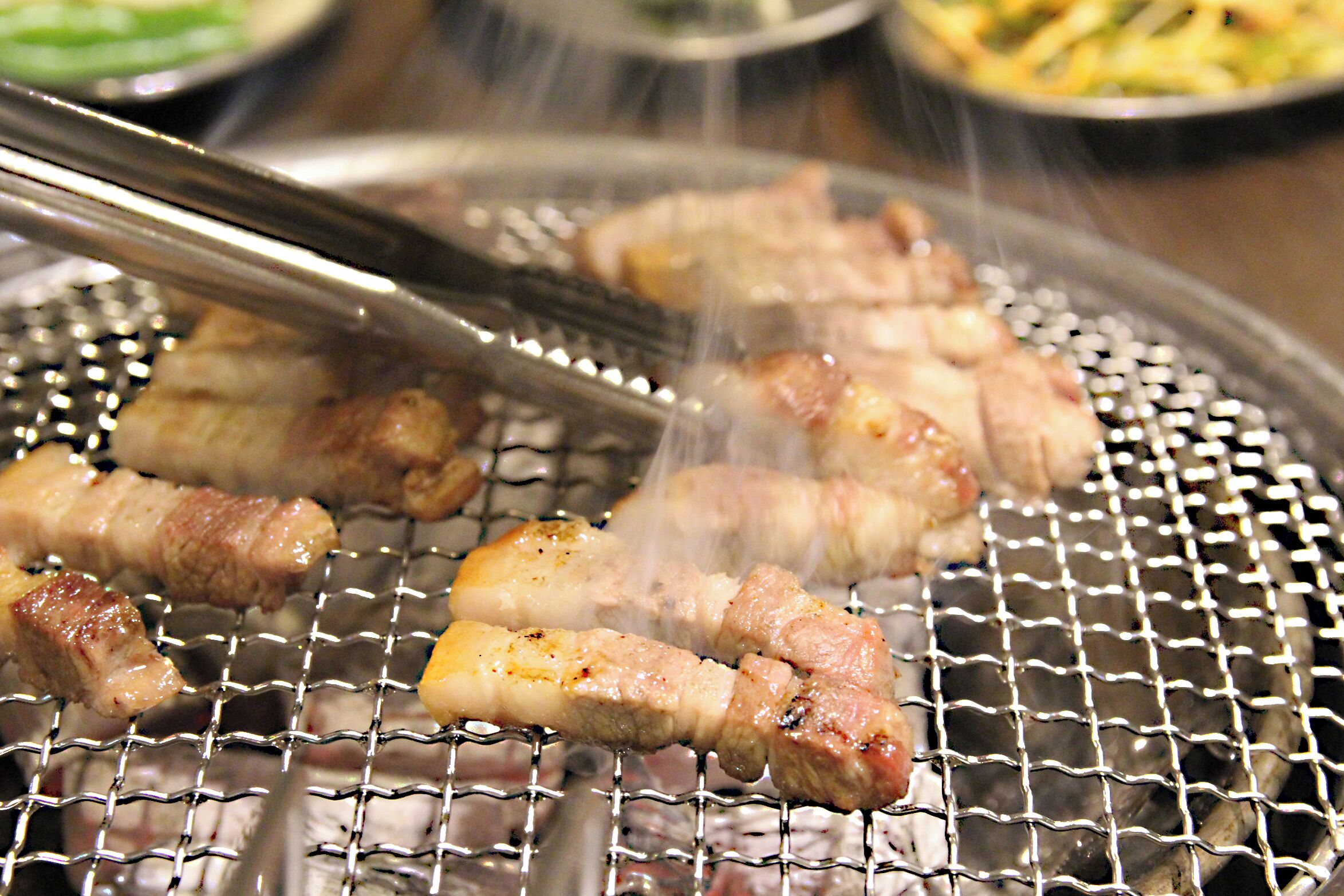 Fleischspieße werden auf einem Grillrost gegrillt.