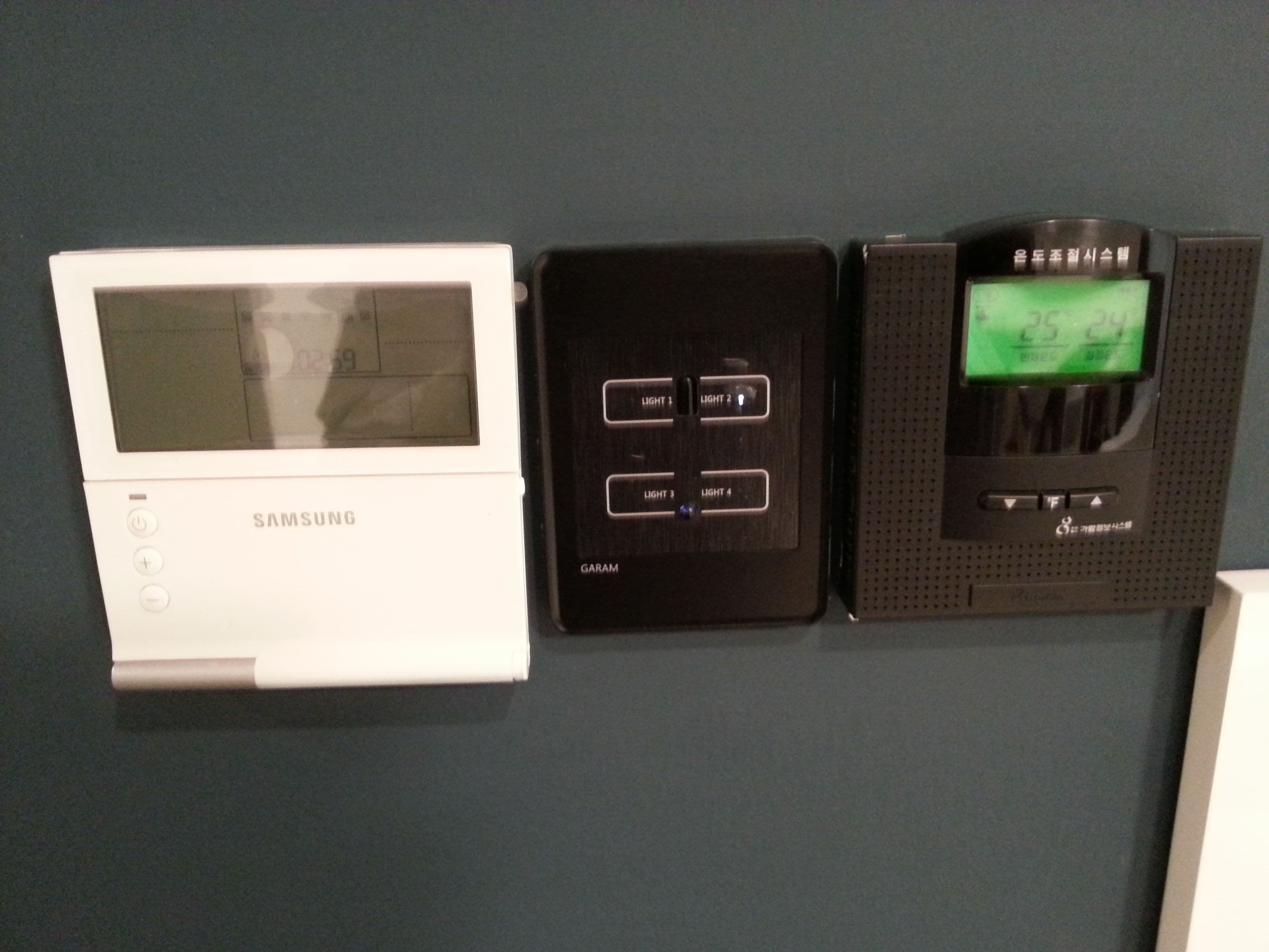 Three devices mounted on a wall, each with a screen and control buttons.