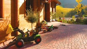 A wooden house with a paved driveway, a small tree, and a toy tractor. - Apartment 'Horizonte' with Balcony and Wi-Fi (Oberkirch)