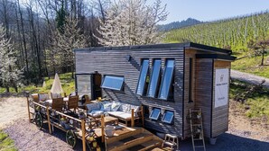A modern, compact wooden building with a patio area, outdoor seating, and a small garden. - Apartment 'Horizonte' with Balcony and Wi-Fi (Oberkirch)