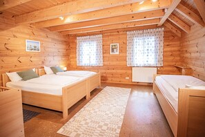 Una cabaña de madera con dos camas de madera, una mesita y un radiador.