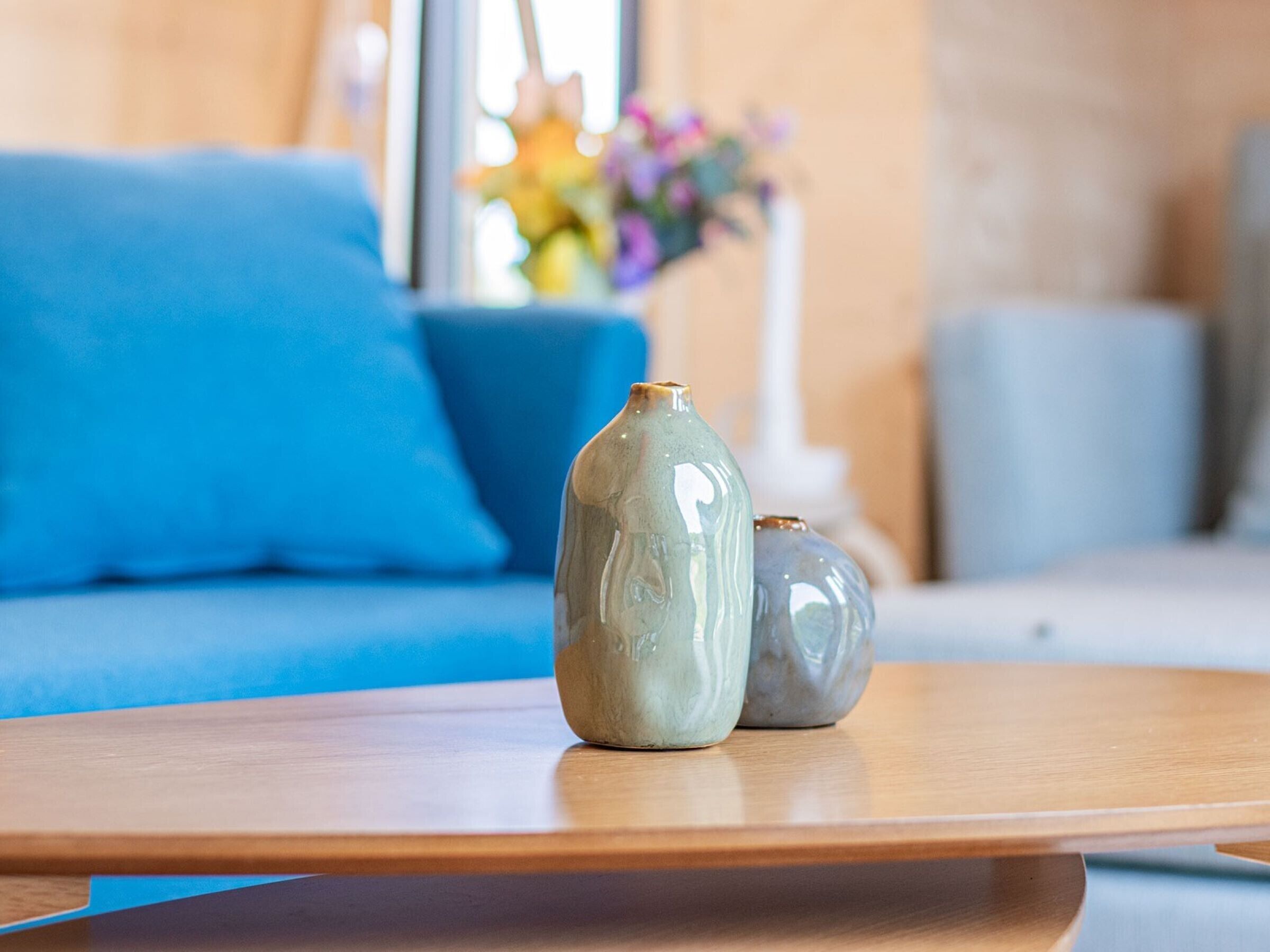A wooden table with two ceramic vases.
