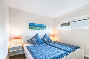 A bedroom with two beds, white headboards, and a window with blinds. - Apartment 'Erwin' with Shared Terrace, Shared Garden and Wi-Fi (Breklum)