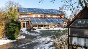 A building with solar panels on the roof, a brick exterior, and a paved pathway leading to the entrance. - Apartment 'Stine' with Shared Terrace, Shared Garden and Wi-Fi (Breklum)