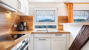 Una cucina compatta con una finestra, un lavello e un fornello.