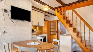 A kitchen with white cabinets, a wooden dining table, and a wooden staircase. - Apartment '2- Ost' with Private Garden, Balcony and Wi-Fi (Sankt Märgen)
