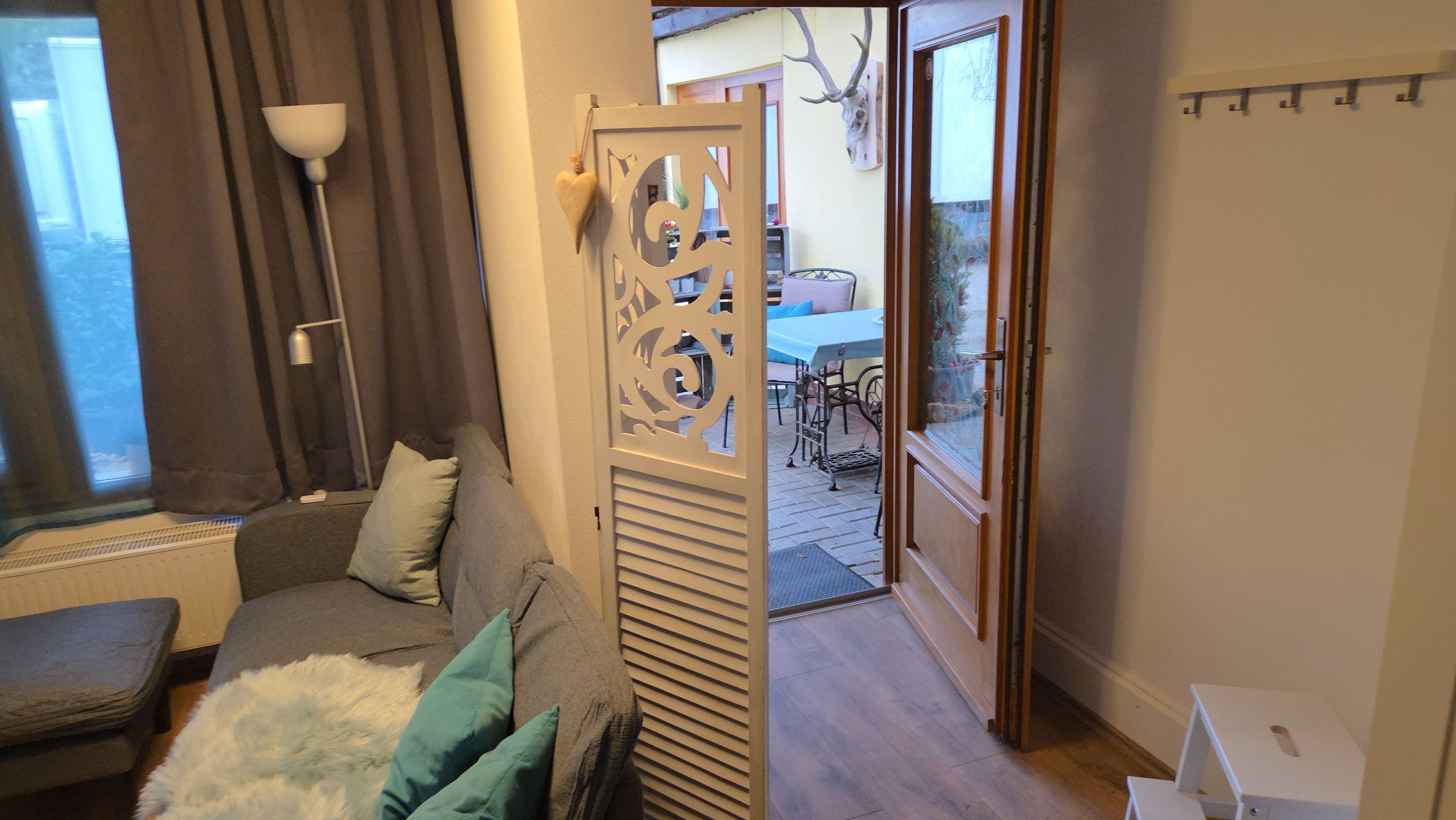 Ett mysigt rum med en soffa, en dekorativ avskärmning och utsikt över omgivningen.
