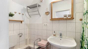 Een badkamer met een wastafel, spiegel, handdoekhouder en toilet.