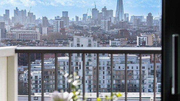 A dining table with a view of a city skyline, including a prominent skyscraper. - Horizon: A Modern Luxury Studio (London)