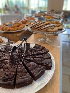 Une table de desserts avec divers produits de boulangerie et un gâteau au chocolat.