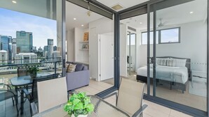 A modern apartment with a balcony, a dining area, a bedroom, and a living room. - Panorama river view with Free Parking (South Brisbane)