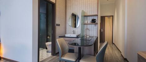 Un bagno moderno con cabina doccia in vetro, lavandino e specchio.