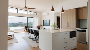 Una cocina moderna con una isla grande, armarios de madera y vista a la ciudad.