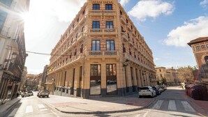 A multi-story building with a central entrance, balconies, and a street view. - The Central House Granada Elvira Hostel (Granada)