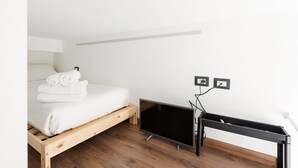 Ein Schlafzimmer mit einem Bett, einem Fernseher und einem Schreibtisch.