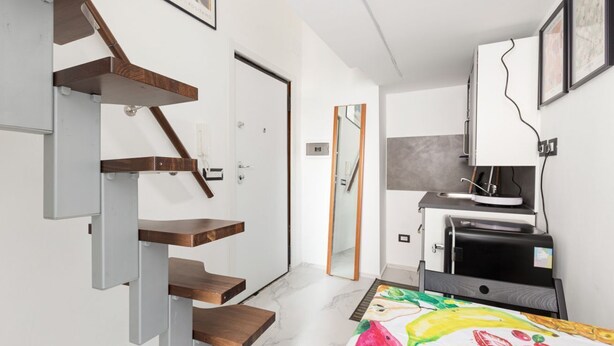 Ein modernes Interieur mit einer Holztreppe, einer Küchenzeile und einem Essbereich.