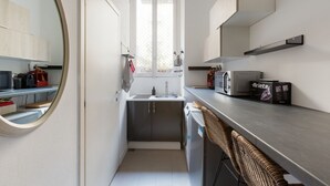 A compact kitchen with a sink, microwave, and cabinets.