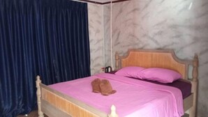 Un dormitorio con cama de madera, ropa de cama rosa y cortina azul oscuro.