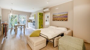 Une chambre à coucher moderne avec un lit, des tables de chevet, une fenêtre et un tableau.