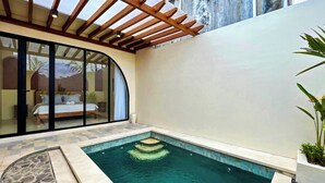 A private pool area with a wooden pergola, a glass-enclosed bedroom, and a stone-tiled deck. - Esha Private Pool Villas by AGATA (Ungasan)