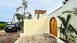 A house with a stone-paved entrance, a wooden door, and a wooden pergola. - Esha Private Pool Villas by AGATA (Ungasan)