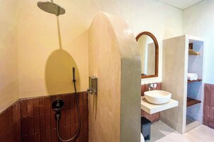Un baño con ducha, lavamanos y espejo.