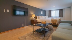 Une chambre d’hôtel moderne avec un grand lit, un canapé, une télévision et une petite table.