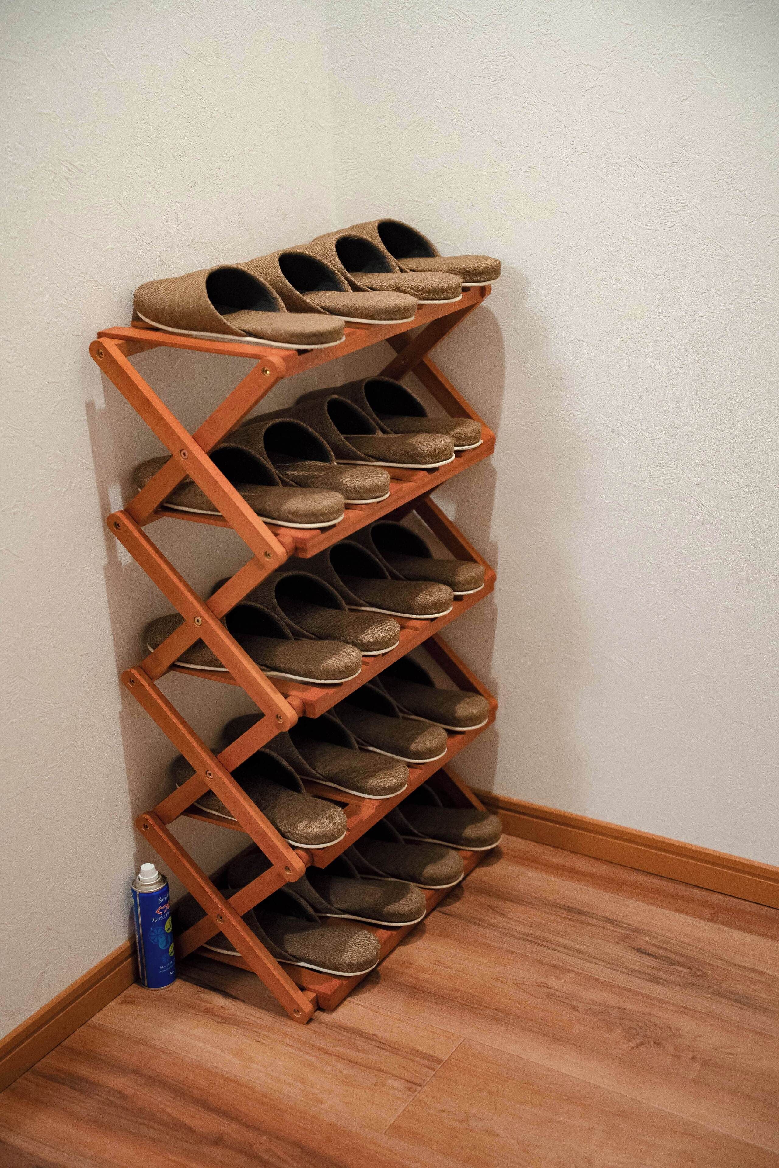 A shoe rack with multiple shelves holding shoes.