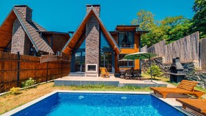 A modern house with a swimming pool, wooden deck, and outdoor furniture. - SAPANCA GRANDWOODEN SUİT  (Sapanca)